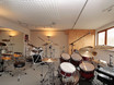 ein großer heller Unterrichtsraum mit professionellem drum & Soundequipment