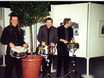 ﻿Tony, Cloy und Hans-Martin spielen im Foyer des Gasteig einen Trommelwirbel, während eineriesige Geburtstagstorte aufgefahren wird.